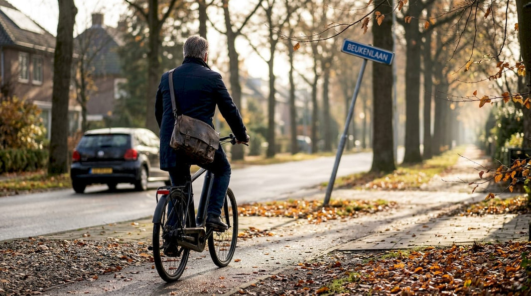 Een vrouw fietst op haar e-bike door een brede stadslaan op een frisse ochtend.