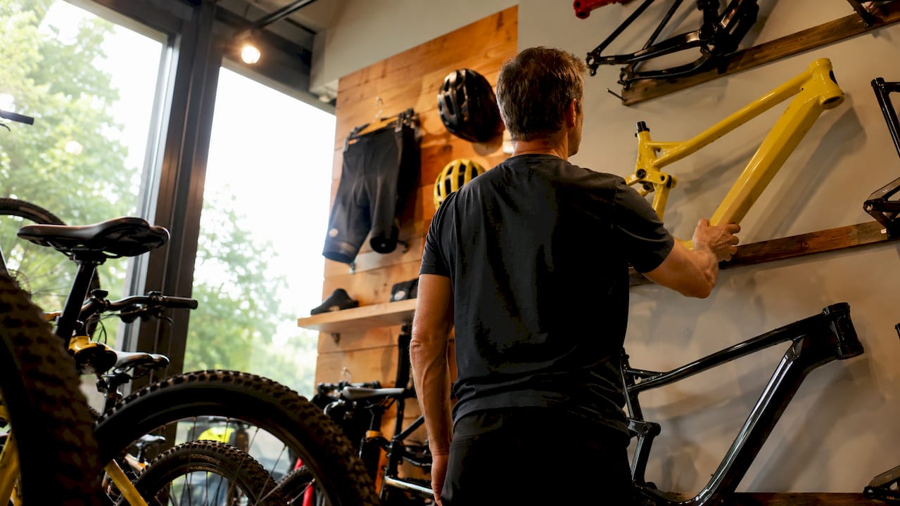 Man bekijkt aandachtig een fietsframe in de fietsenwinkel
