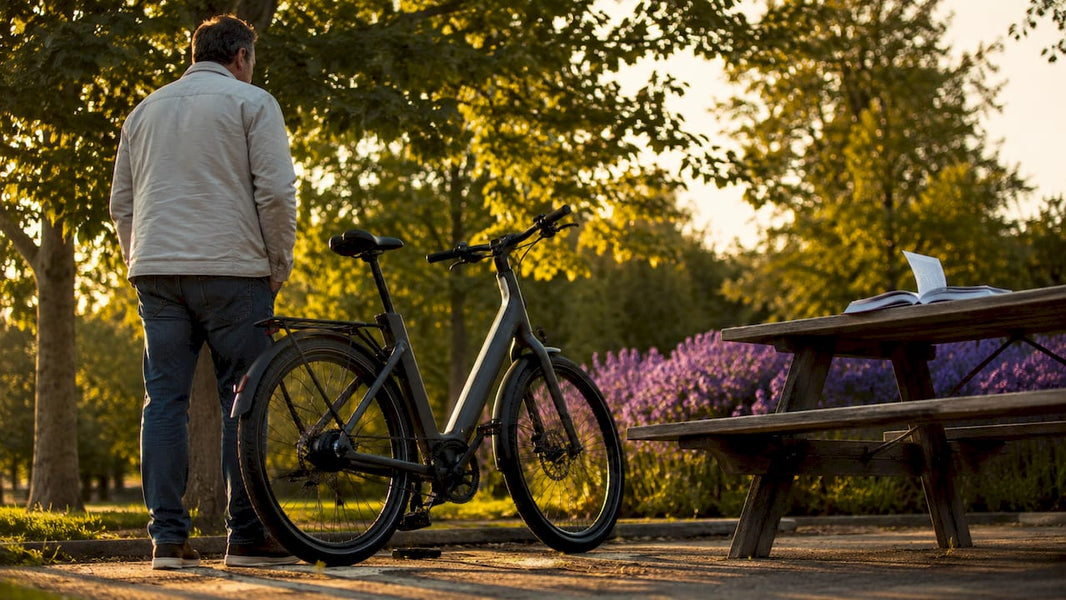 Een man bekijkt een e-bike vanaf de achterkant.
