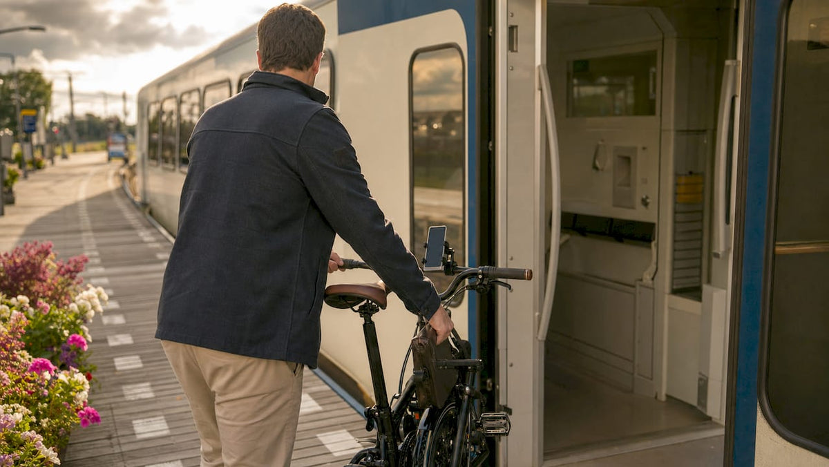 Een man tilt zijn fiets vanaf de achterkant in het fietsrek van de trein.
