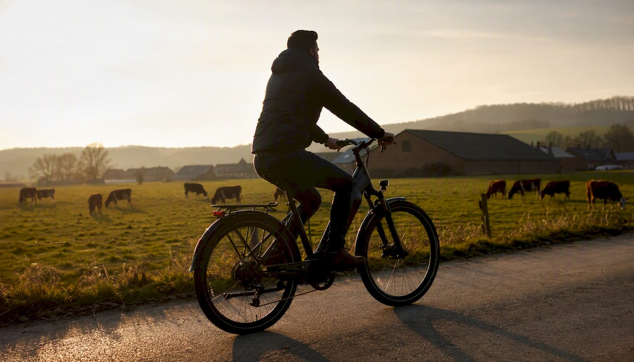 Een man maakt een fietstocht op zijn toerfiets door het typisch Nederlandse landschap.