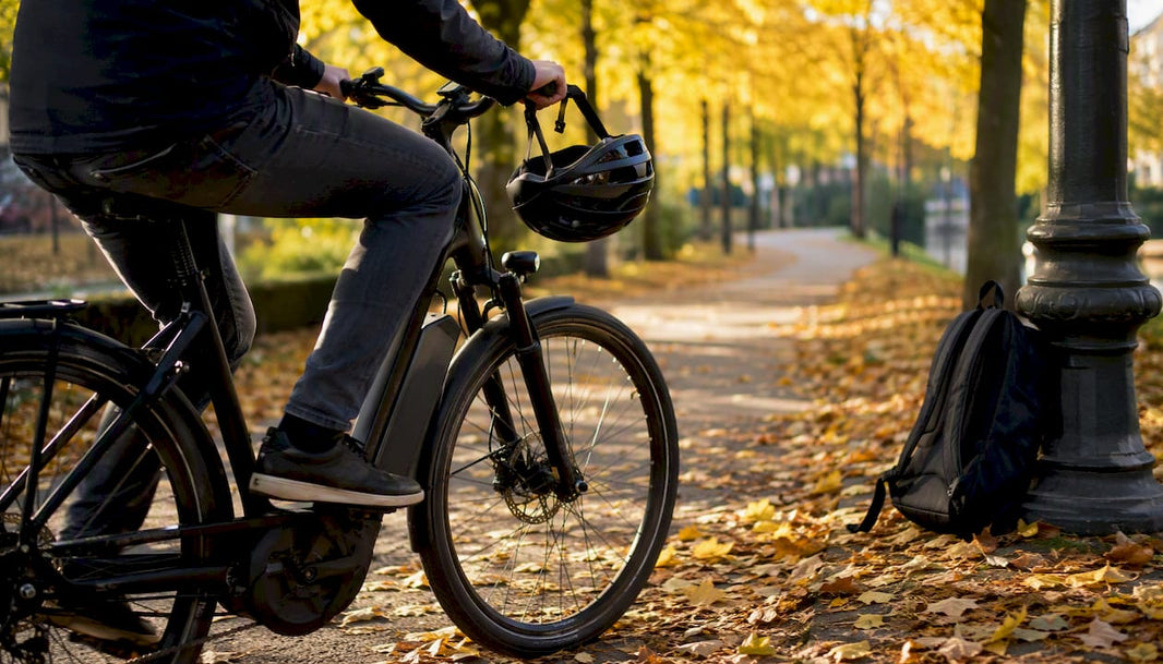 Een man fietst op zijn e-bike naar zijn werk, gezien van achteren.
