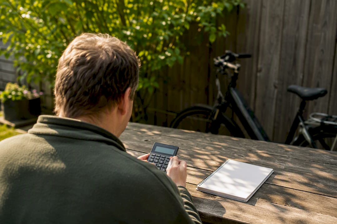 Man die de kosten van een e-bike lease aan zijn bureau berekent